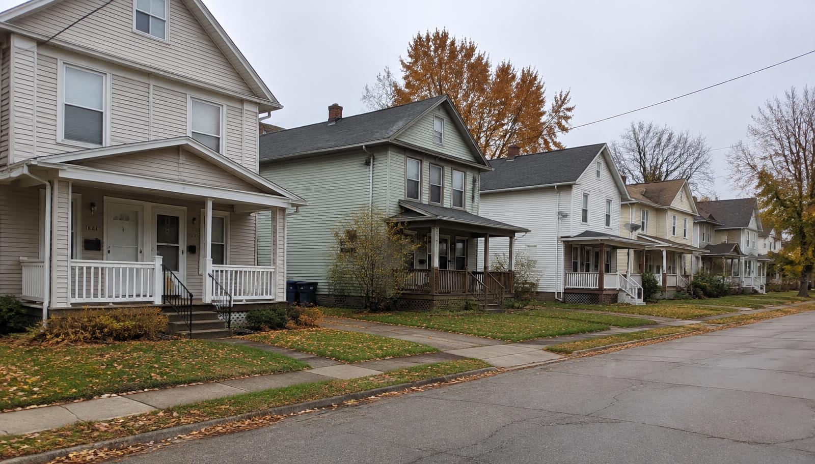 Illustrative photo: a street of older wood-frame houses with porches in autumn